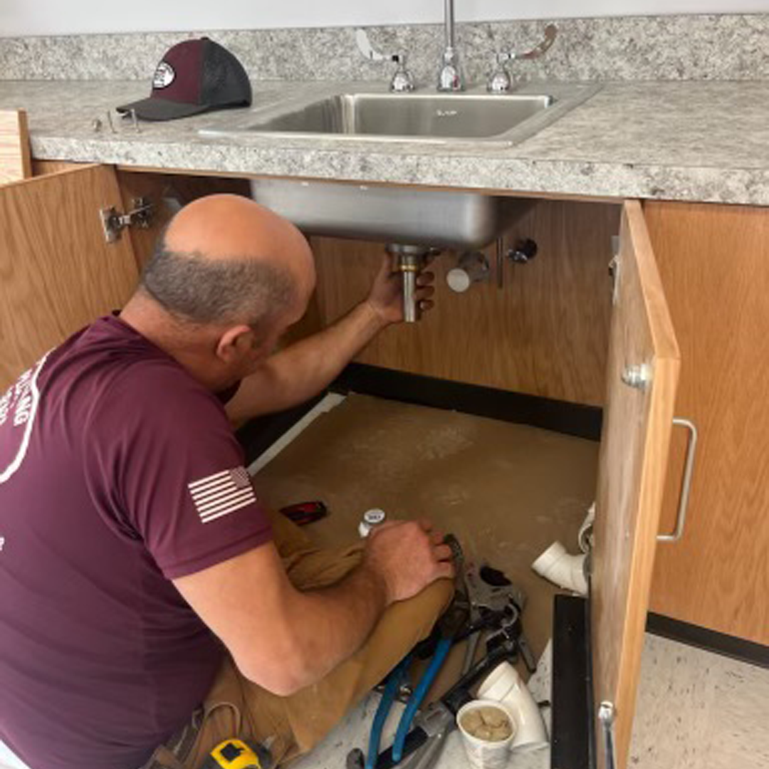 Under-kitchen-sink-plumbing-showing-water-supply-lines Under kitchen sink plumbing showing water supply lines P-trap and garbage disposal connections to inspect for freeze damage