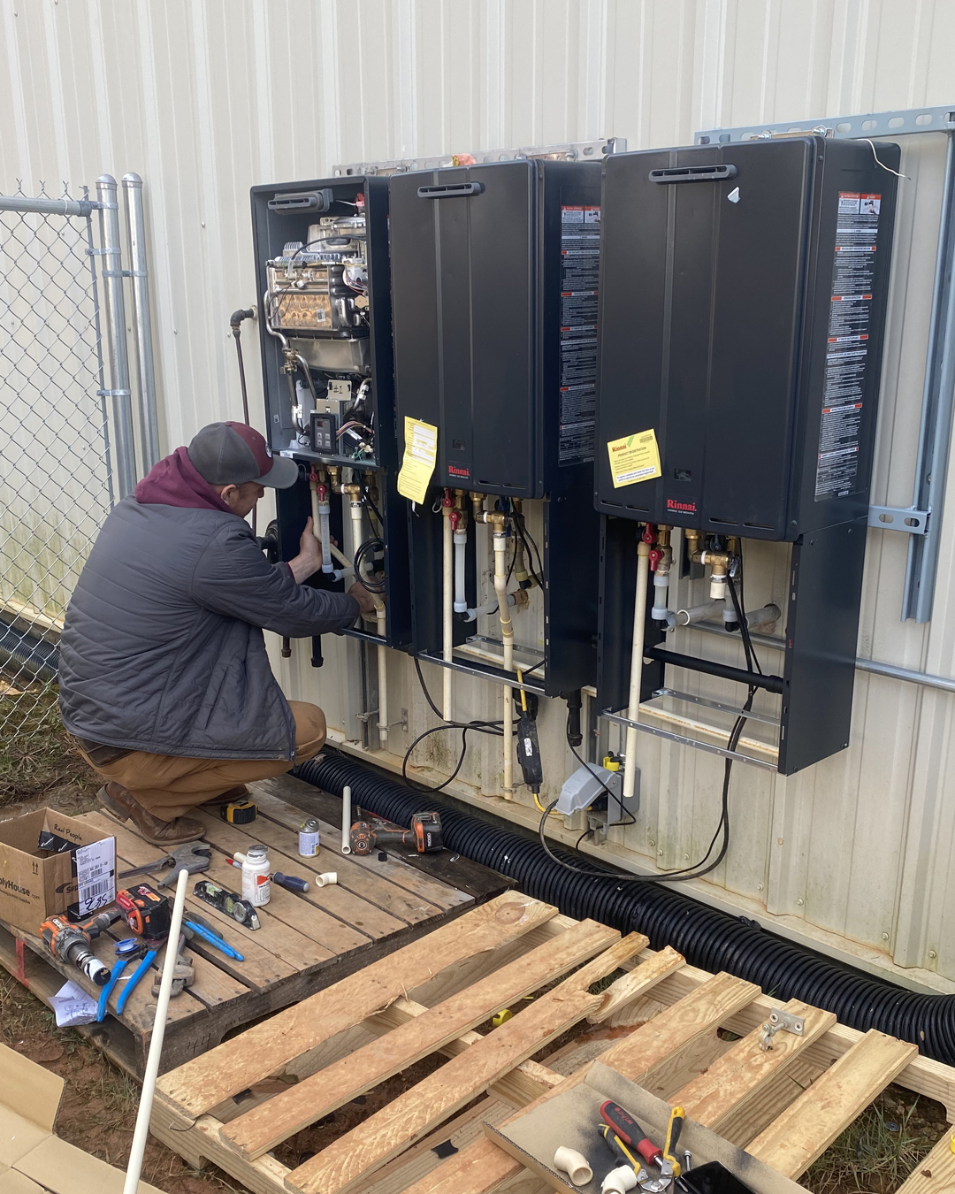 Ohmstead Plumbing technician installing a tankless water heater in a tight closet in Shelby NC