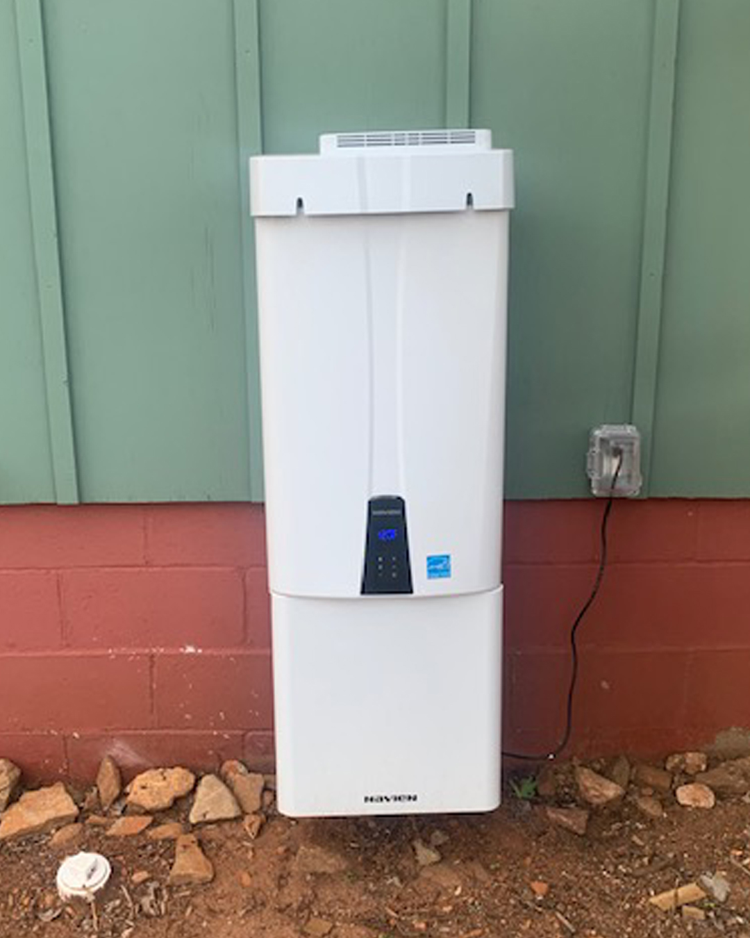 Ohmstead Plumbing technician installing a water heater in a Forest City NC utility closet